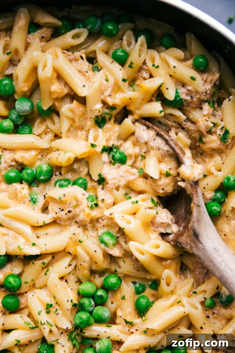 Finished Tuna Pasta in Skillet - Spoon Scooping a Serving The finished tuna pasta recipe in a skillet, with a spoon scooping up a portion.