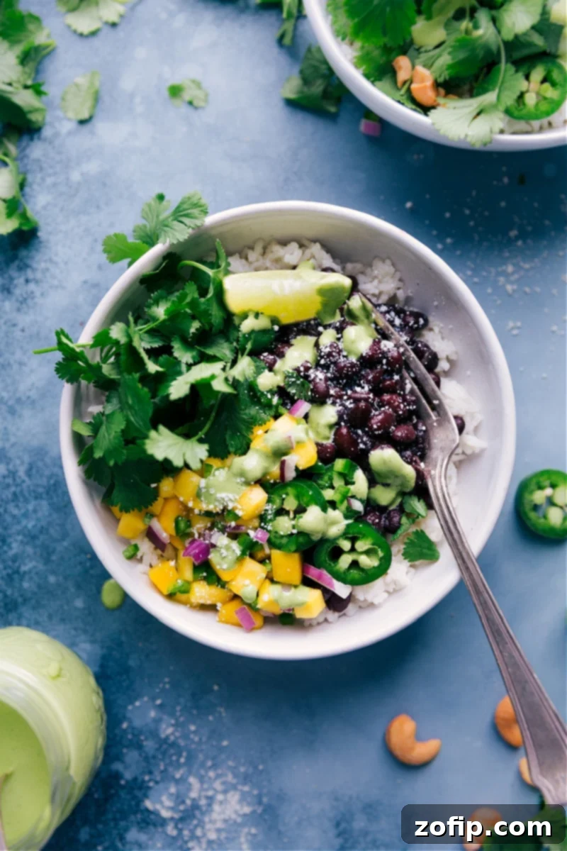 Black Bean Power Bowls 2 Overhead view of Black Bean Bowls with all the vibrant toppings, including a drizzle of creamy sauce.
