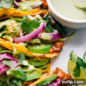 Zesty Pinto Bean Tacos 2 A close-up of a stack of Pinto Bean Tacos, showing the rich bean filling, colorful slaw, and various toppings.
