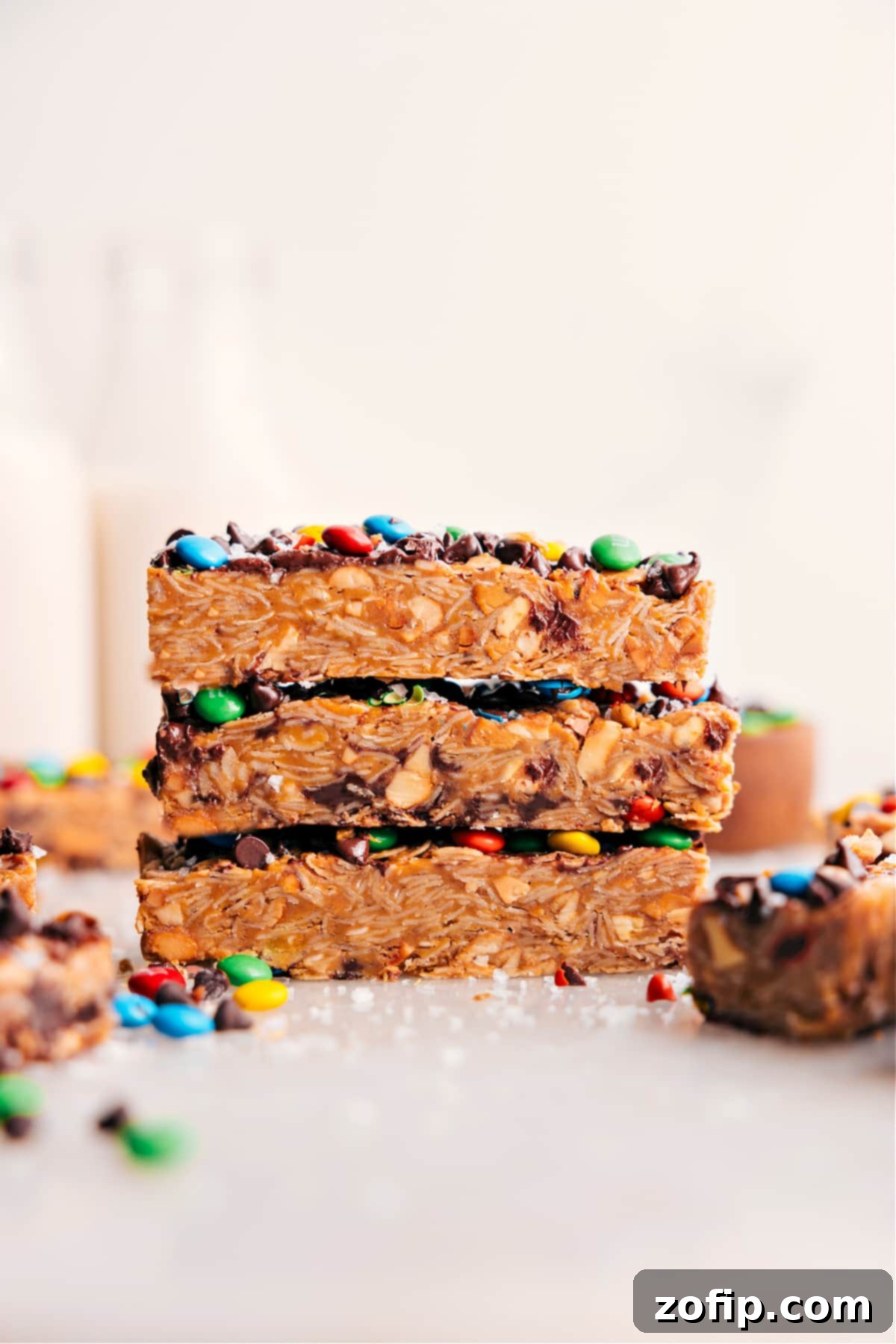 The Best Chewy Granola Bars Recipe Stacked homemade chewy granola bars with M&M's and chocolate chips, showcasing their delicious texture.