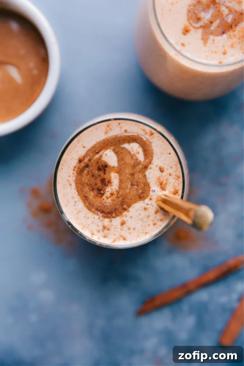 Overhead image of two creamy Cauliflower Smoothies garnished with a sprinkle of cinnamon, in clear glasses.