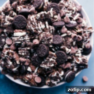 A bowl filled with irresistible Cookies and Cream Muddy Buddies, featuring the chocolate-coated cereal, Oreo crumbs, and white chocolate drizzle, ready to be enjoyed.
