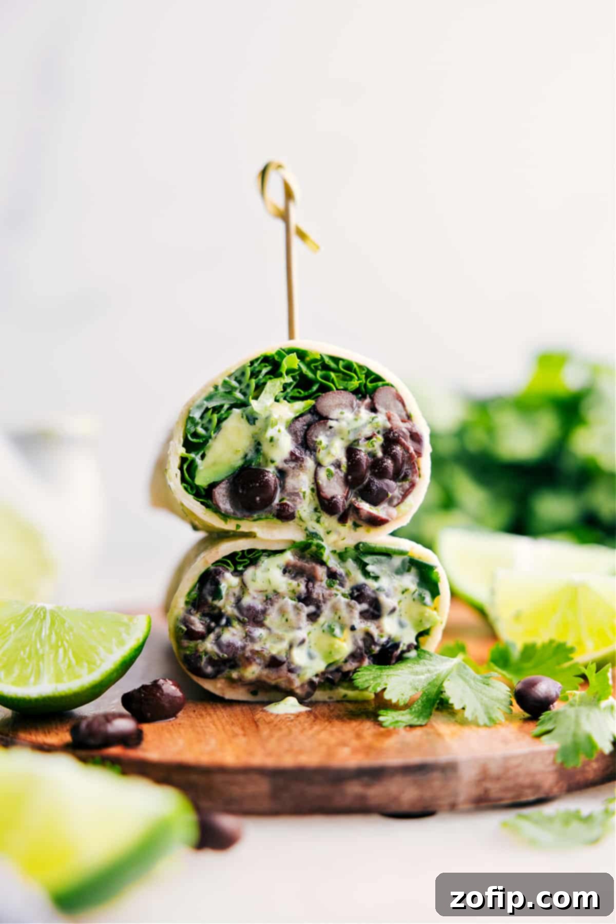Delicious Black Bean Wraps, expertly cut in half and attractively stacked, showcasing their vibrant filling of beans, avocado, and lettuce.