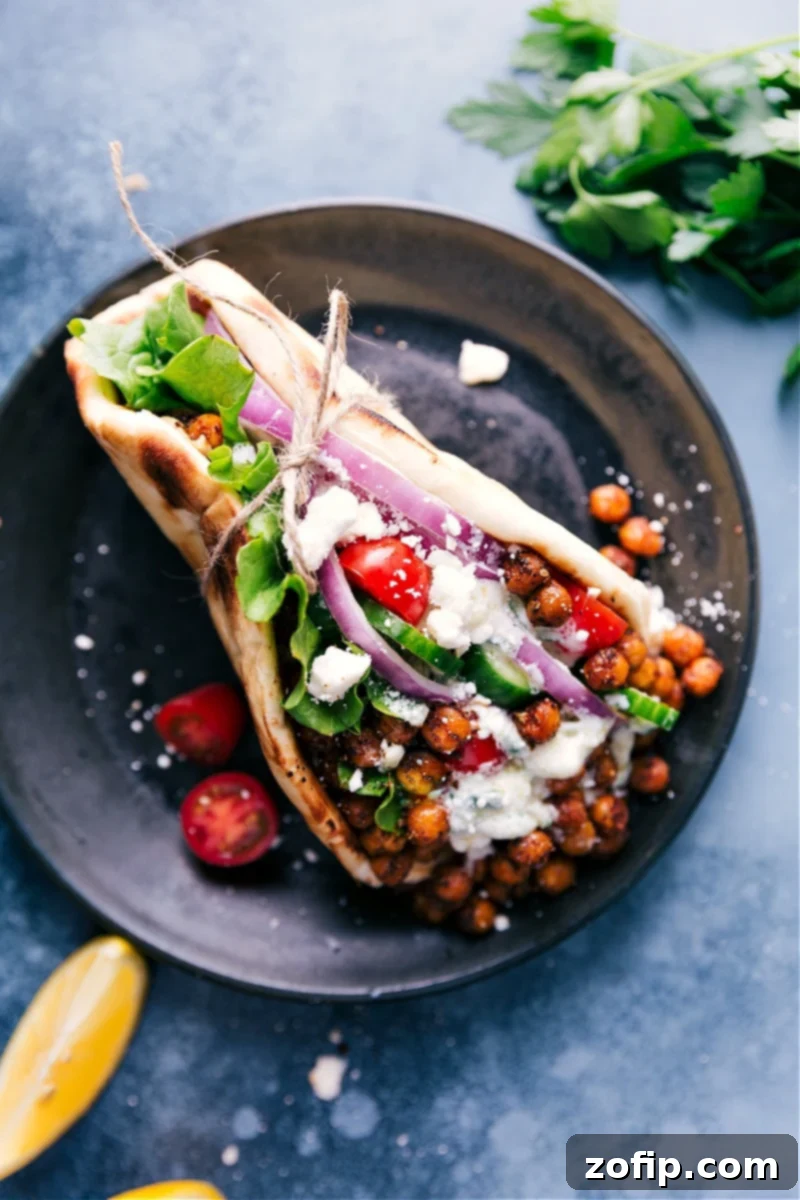 This easy, weeknight meal can be ready in about 30 minutes or less if you’ve got an air fryer! #dinner #healthy #whole #whole30 #best #quick #easy #simple #greek #vegetarian #gyros Overhead view of a beautifully assembled Vegetarian Gyro, bursting with roasted chickpeas, fresh vegetables, and tzatziki.