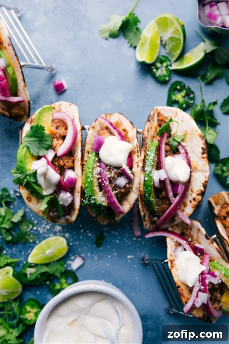 Three Ground Pork Tacos with lime crema, avocado, and pickled onions