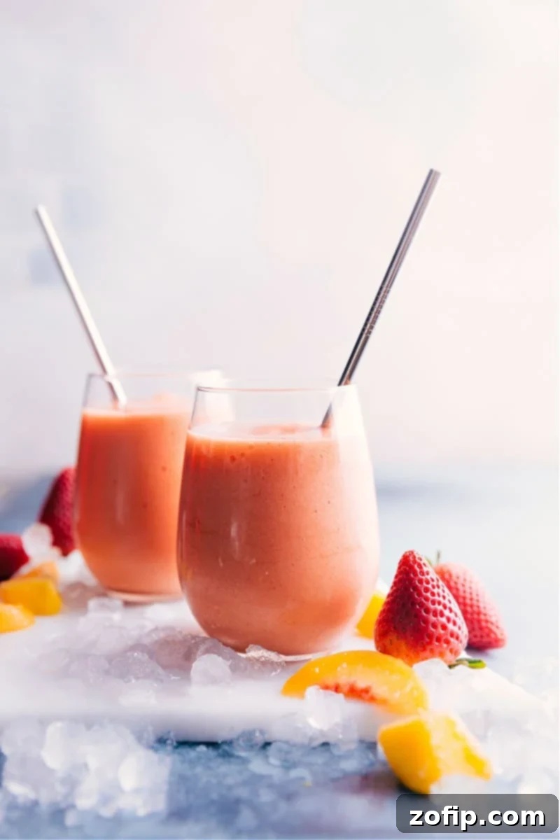 Two glasses of Caribbean Passion Smoothies, garnished with fresh fruit, on a vibrant tropical background.