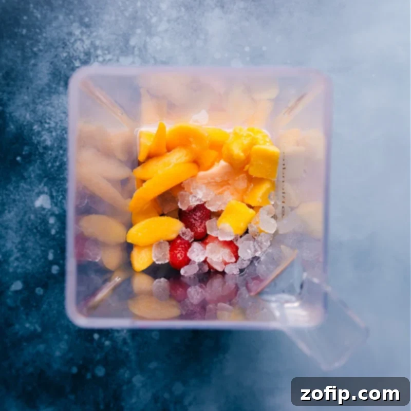 All the vibrant ingredients for the Caribbean Passion Smoothie, including passion fruit juice, frozen fruits, orange sherbet, and ice, artfully arranged in a high-powered blender, ready to be processed.