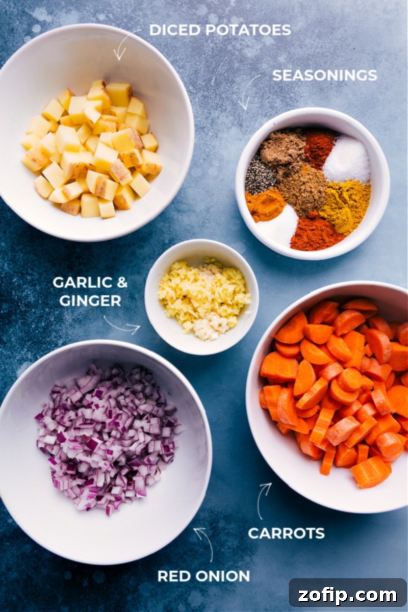Essential ingredients for a delicious Curry Lentil Soup, featuring red lentils, fresh vegetables, and a medley of aromatic spices. A vibrant selection of fresh ingredients including red lentils, carrots, onions, ginger, garlic, and an array of spices, neatly arranged for making Curry Lentil Soup.