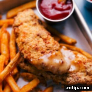 Crispy Air Fryer Chicken Tenders plated and ready to be served with a side of honey-mustard dipping sauce.