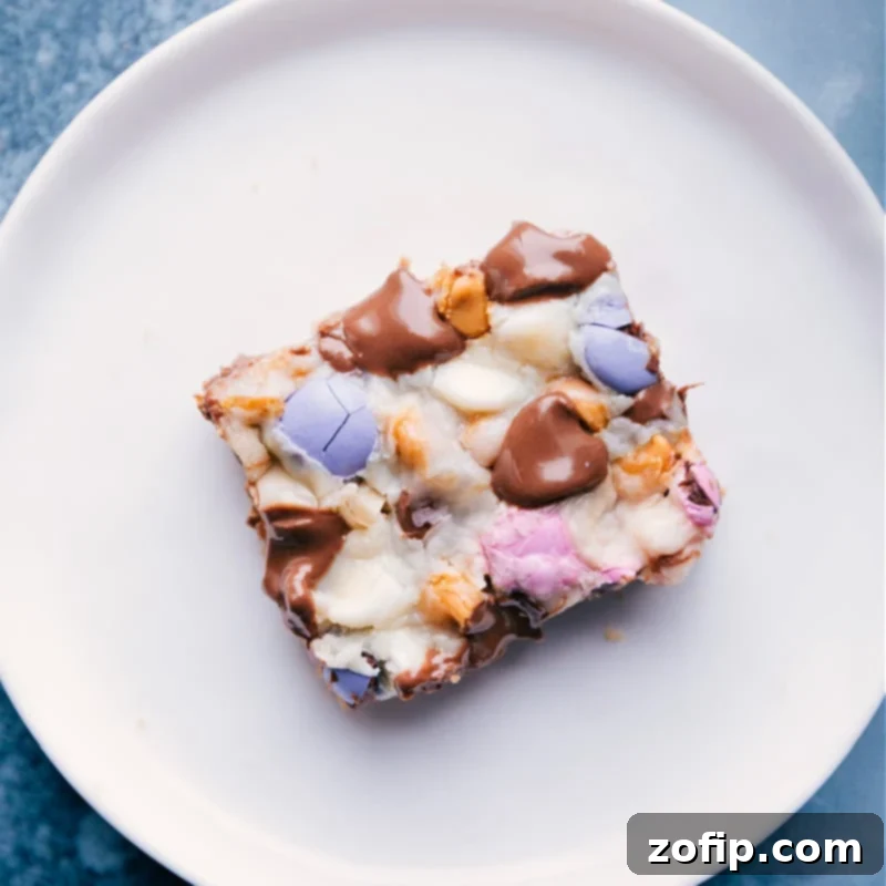 A single, perfectly portioned Magic Bar resting on a plate, showcasing its golden crust and topping medley.