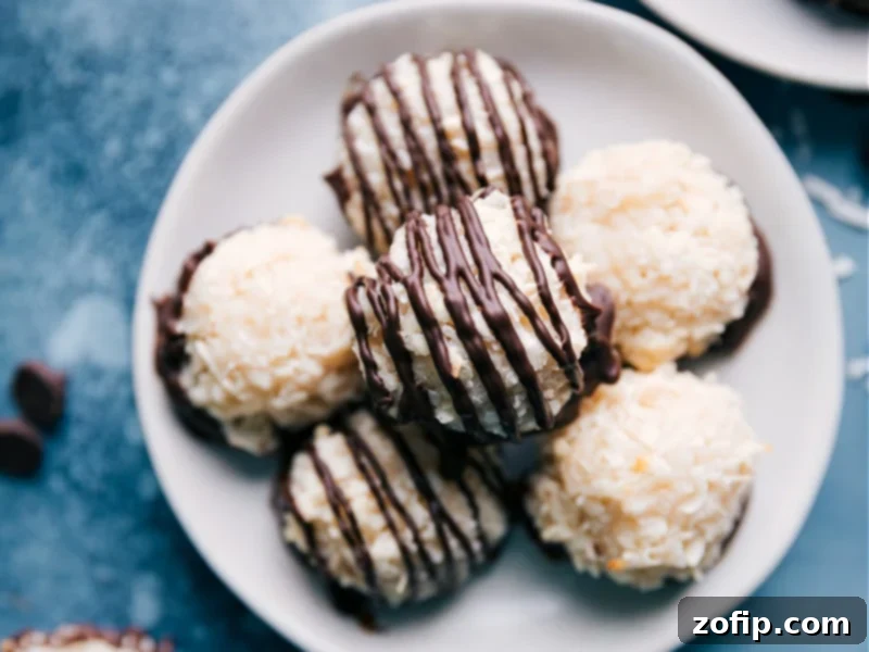 Simple Coconut Macaroons are made with minimal ingredients thanks to the "secret" -- sweetened condensed milk! These macaroons are sweet, chewy, and completely addictive, especially when dipped and drizzled in chocolate! If you are a coconut lover, you are going to go crazy for these cookies. Close-up of baked Coconut Macaroons on a cooling rack