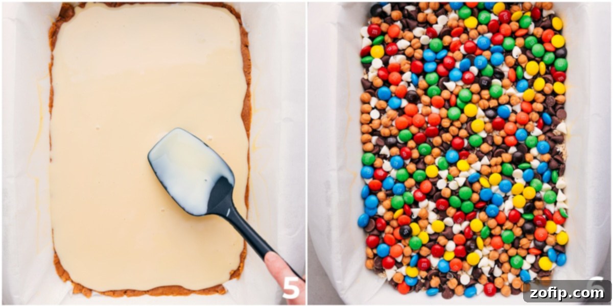 All the delicious layers of Magic Cookie Bars, including sweetened condensed milk, quick oats, chocolate chips, white chocolate chips, caramel bits, and M&Ms, assembled in a baking pan, ready for the oven.
