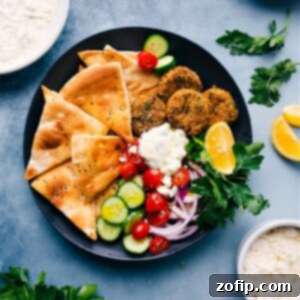Crispy Air Fryer Falafel patties on a serving plate with pita and tzatziki.