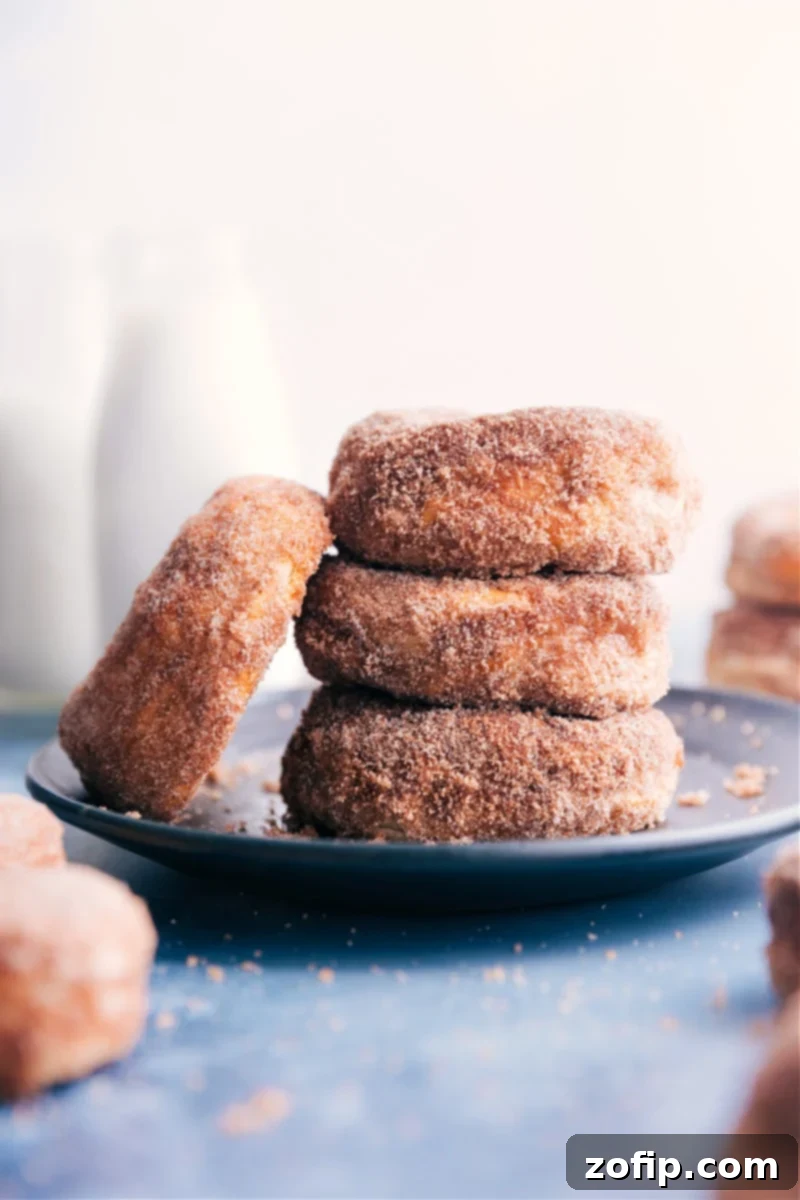 Image of Air Fryer Donuts stacked on top of each other, glistening with cinnamon sugar
