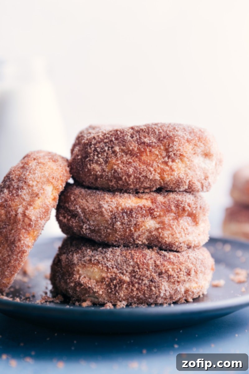 Up-close image of Air Fryer Donuts stacked on top of each other, showcasing their fluffy texture and cinnamon-sugar coating.