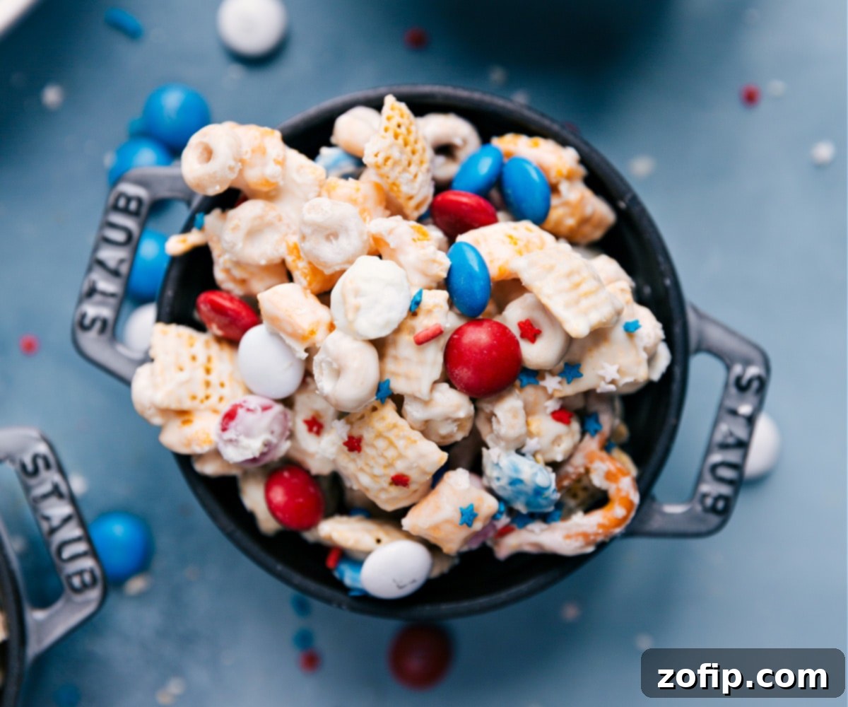 Presenting The Best 4th Of July Snack Mix A large ceramic bowl filled with the completed 4th of July snack mix, featuring a festive arrangement of red, white, and blue elements, ready to be served.