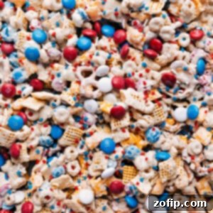 Patriotic Party Mix 3 A festive bowl of 4th of July Snack Mix, featuring red, white, and blue M&M's, pretzels, and cereal, perfectly coated in white chocolate.