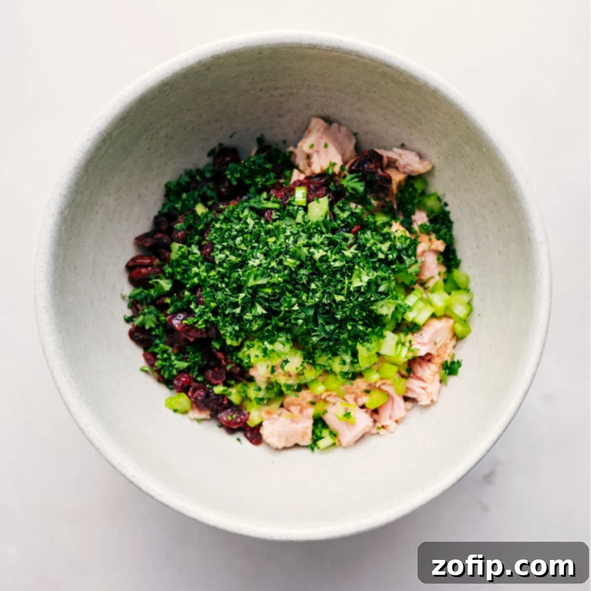 All the prepped ingredients for this easy tuna salad are combined in a large mixing bowl, ready to be tossed together to create a creamy, flavorful dish.