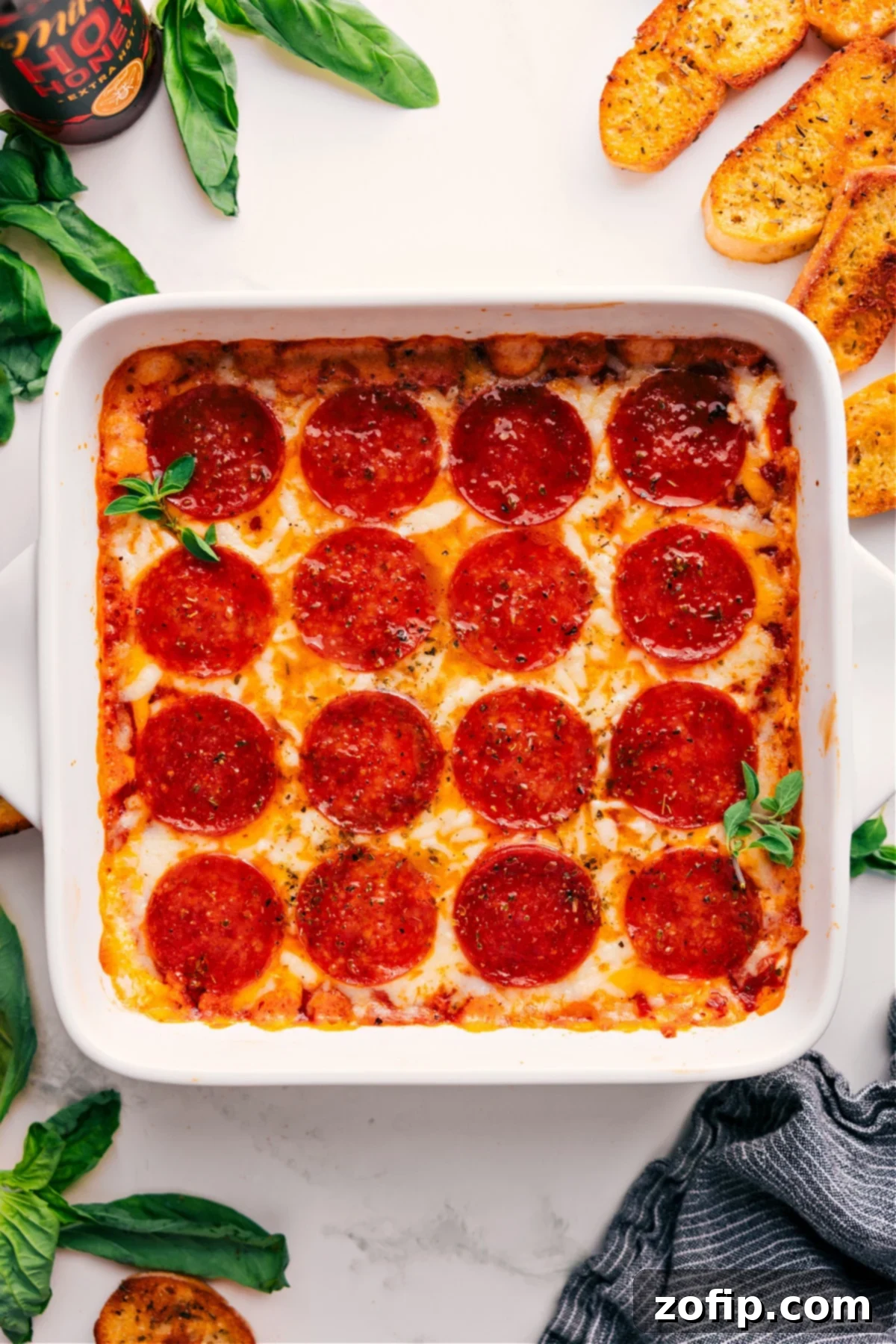 Irresistibly Delicious Pizza Dip Recipe Pizza Dip Recipe fresh out of the oven with fresh basil on top.