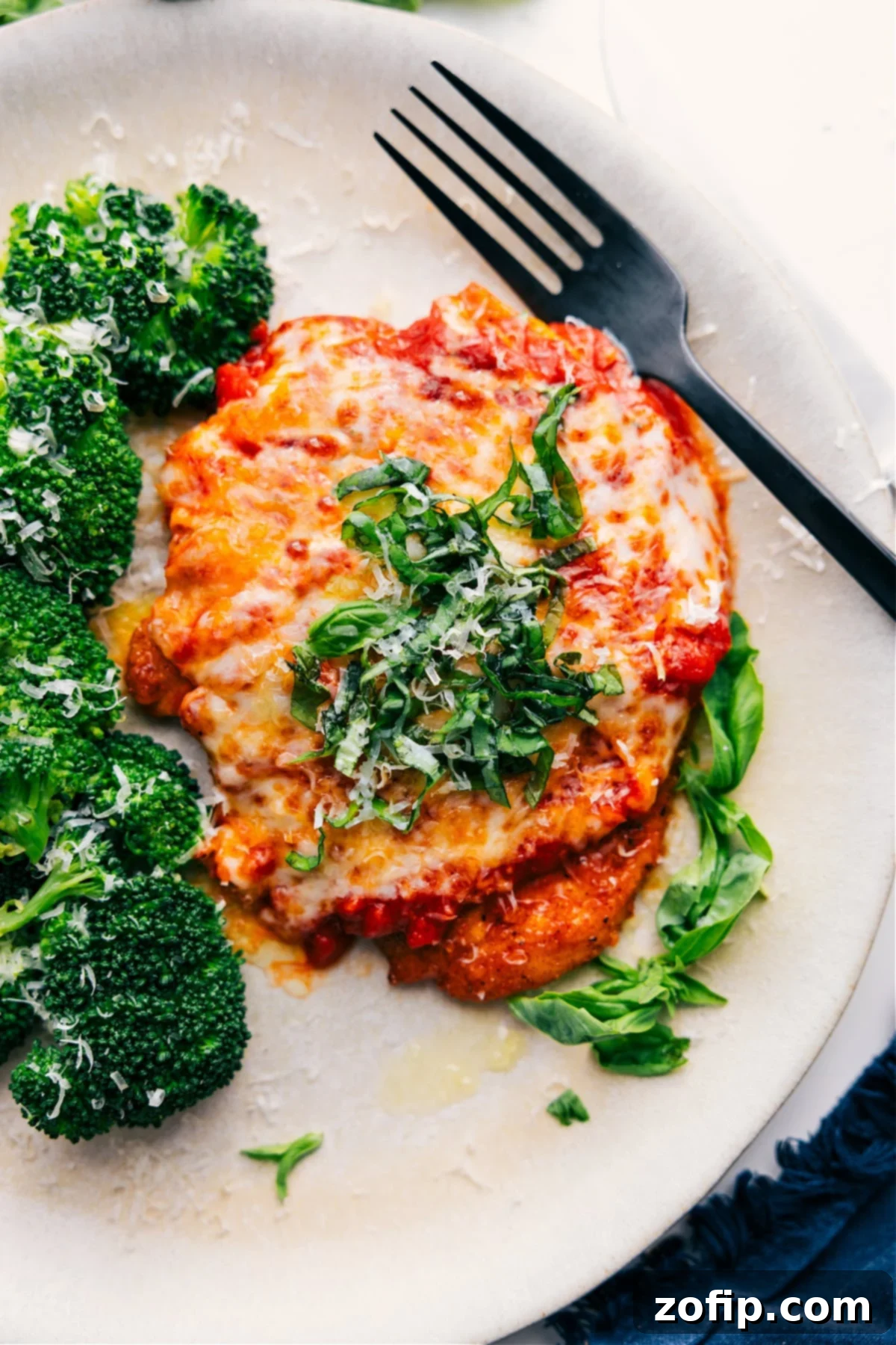 Pure Comfort Food: Parmesan Chicken Recipe Parmesan Chicken Recipe with fresh Parmesan and basil on top, ready to be enjoyed.