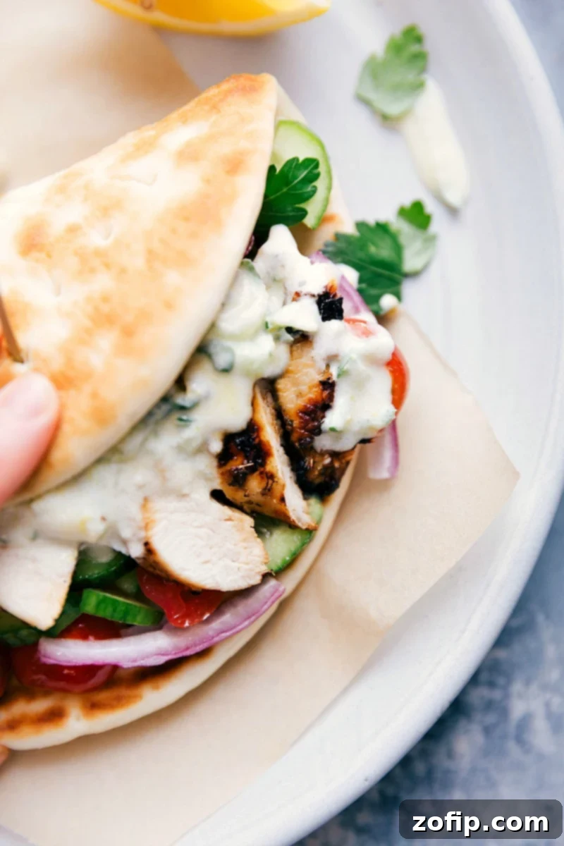 A mouthwatering chicken gyro wrapped in pita bread, filled with seasoned chicken, fresh vegetables, and creamy tzatziki sauce.