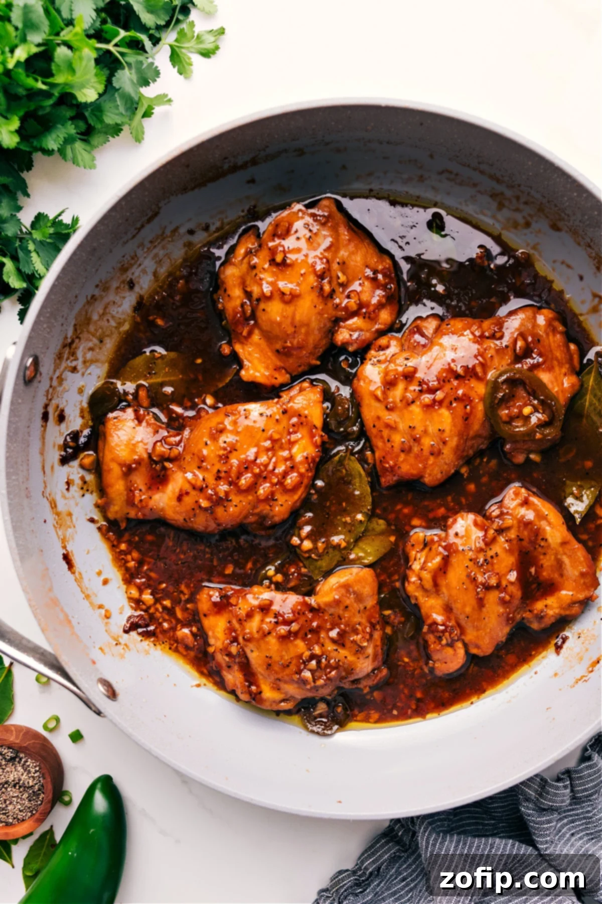 Chicken Adobo Delight 2 Chicken Adobo simmering in a pot, coated in a rich, glossy sauce.